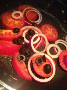 Luomumunista pyöräytetty auringonkeltainen munakas saa lisäväriä tomaatista, punasipulista ja oliiveista.